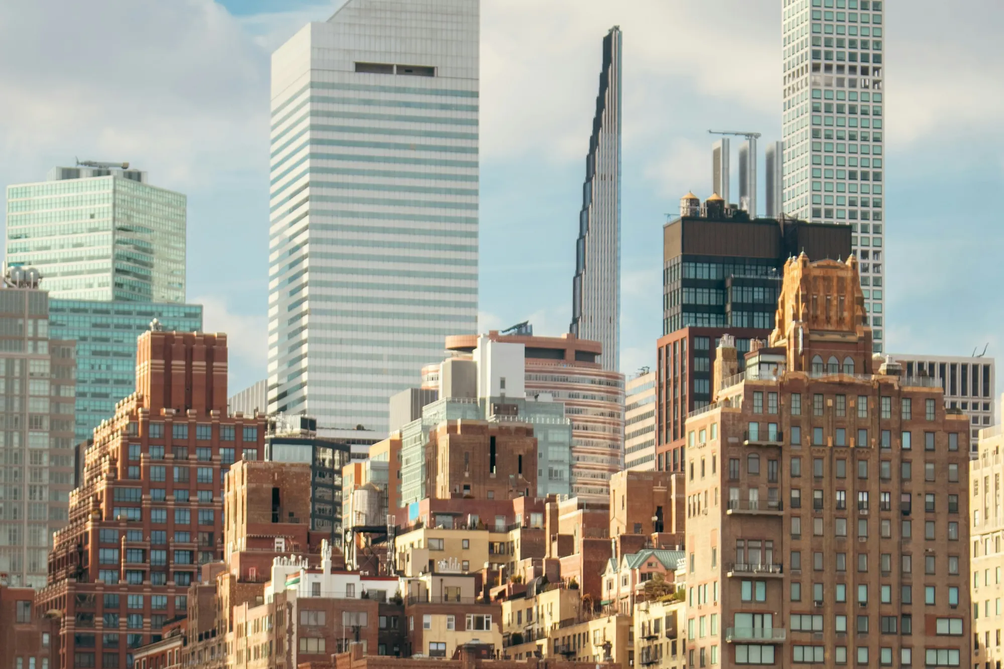 Midtown Manhattan office towers rising above older brick and limestone buildings